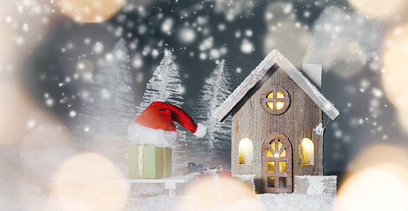 圣诞卡与小发光装饰房子,礼物圣诞老人帽雪橇上的雪上的童话冬天冷杉森林背景下雪新年明信片房子圣诞礼物图片
