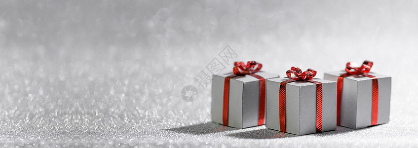 小装饰圣诞礼品盒与红色里宾弓银色闪光背景与圣诞礼盒图片