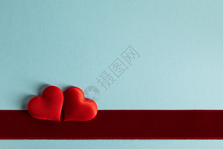 红心背景情人节,两颗红丝心红缎带蓝纸背景上,爱的情人节的心蓝色背景