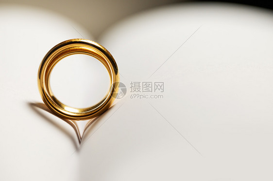 两个金色的结婚戒指空白的书页背景与文本的金色结婚戒指书上图片