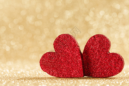 金色的心两颗小小的手工红色闪光的心明亮的金色灯光博克背景情人节卡片上两颗心博克的背景下背景
