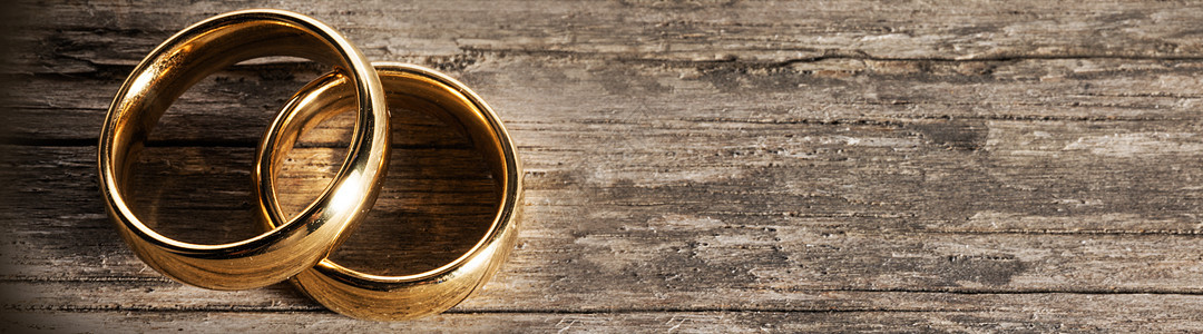 两个金色的结婚戒指木制背景上,有文字的木头上的金色结婚戒指图片