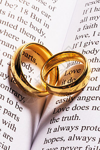 两个金色的结婚戒指神圣的圣经书上与心形阴影圣经书上的金色结婚戒指图片