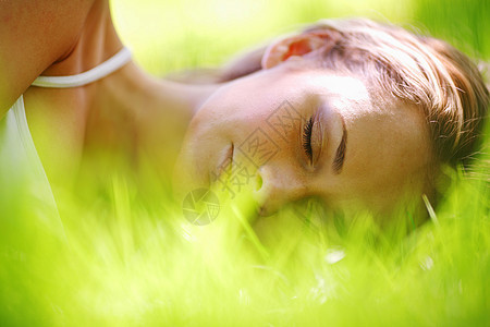 美丽的年轻女人睡绿色的春天的草地上女人睡草地上图片