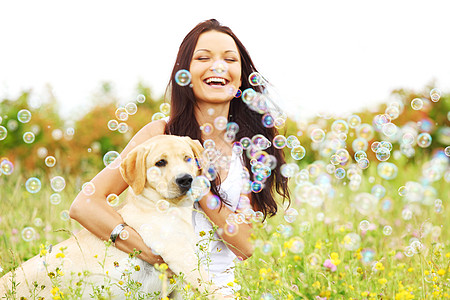 快乐的女人她的拉布拉多狗青草草地上女人狗图片