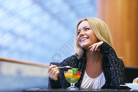 快乐微笑的女人咖啡馆吃水果甜点女人吃甜点图片