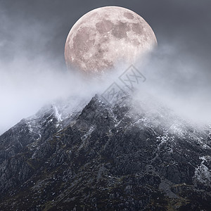 美丽的数字复合图像的超级月亮以上的山脉,给非常超现实的幻想外观戏剧性的景观形象图片