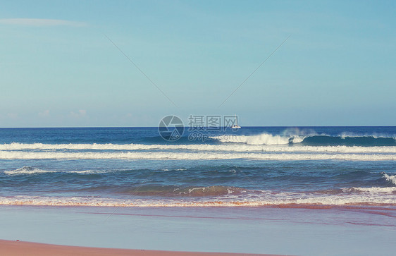 海滩上的蓝色波浪模糊背景阳光斑点平的自然背景图片