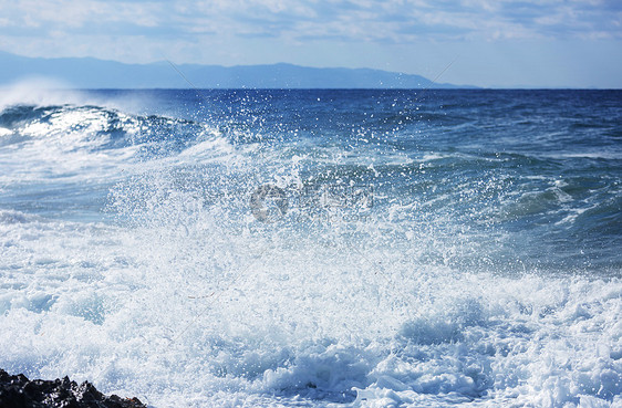 海滩上的蓝色波浪模糊背景阳光斑点戏剧性的自然背景图片
