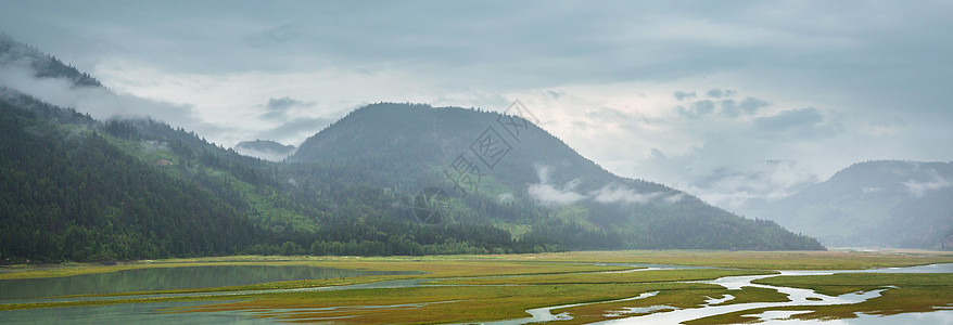 平静的景色加大的山湖旁边,岩石平静的水中反射背景图片