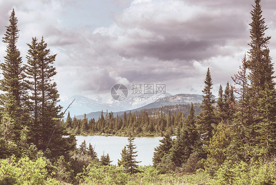 平静的景色加大的山湖旁边,岩石平静的水中反射图片