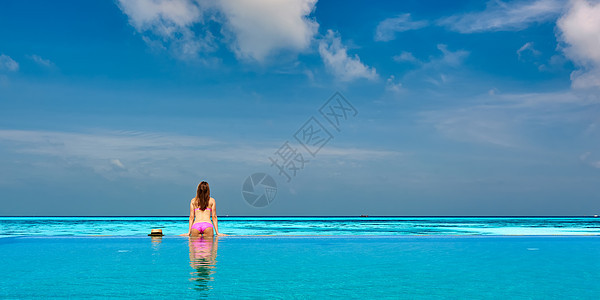女人马尔代夫的无限游泳池里放松图片