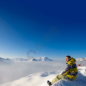 高山冬山景观与人坐低云之上阳光明媚的日子里,法国阿尔卑斯山上覆盖着雪瓦尔drsquoIsere,法国图片