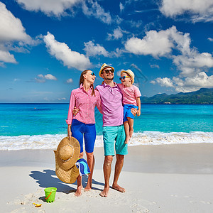 家人美丽的AnseSoleil海滩上,年轻的夫妇三岁的蹒跚学步的男孩马赛尔的暑假图片