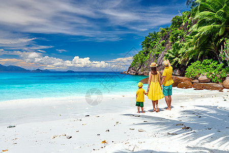 家庭美丽的娇小的Anse海滩,穿着黄色衣服的年轻夫妇三岁的蹒跚学步的男孩马赛尔的暑假图片