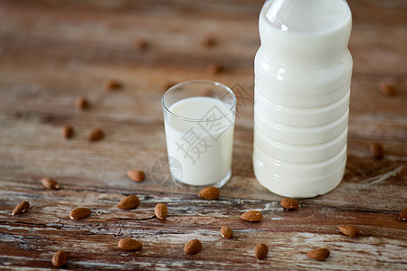 食品乳制品木制桌子上的玻璃瓶牛奶杏仁坚果木桌上的牛奶杏仁图片