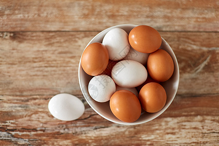 食物,烹饪烹饪天然鸡蛋陶瓷碗木制桌子上把鸡蛋放木制桌子上的陶瓷碗里图片