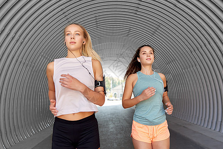 健身运动健康的生活方式年轻女或女朋友戴着带智能手机的,户外跑步带着耳机智能手机的年轻女跑步图片