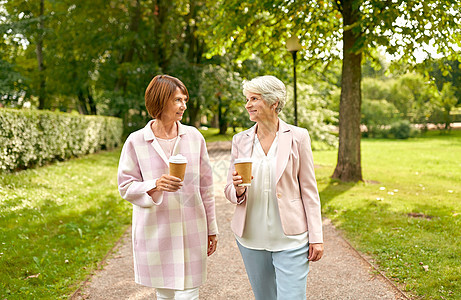 老年退休人的两个高级妇女或朋友公园喝咖啡散步交谈高级妇女或朋友公园喝咖啡图片