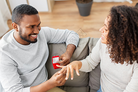 周年纪念,提案夫妇的快乐的非裔美国人男子给钻石订婚戒指小红盒子家里的女人非裔美国男人给女人订婚戒指图片