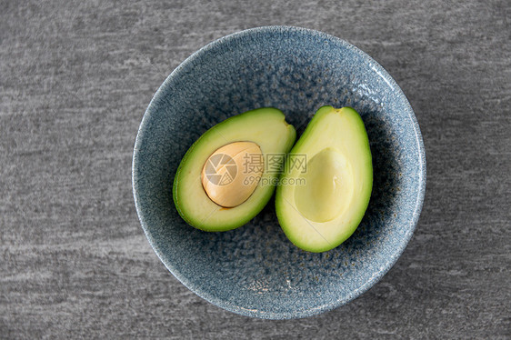 食物,饮食蔬菜的切割鳄梨与骨头陶瓷碗石板石背景把成熟的鳄梨骨头放陶瓷碗里图片