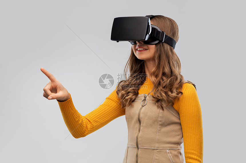 ‘~技术,增强现实娱乐快乐的表妹与虚拟耳机或VR眼镜灰色背景灰色背景下戴VR眼镜的十几岁小姐姐  ~’ 的图片