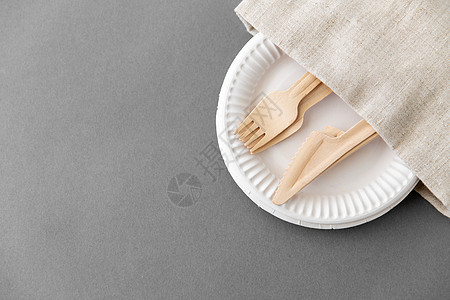 餐具,回收生态友好的木叉刀纸盘帆布餐巾灰色背景纸盘餐巾上的木叉刀背景图片