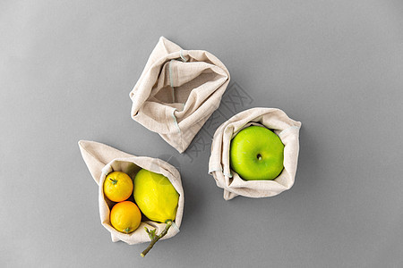 消费主义生态友好的水果可重复用的帆布袋食品购物的灰色背景水果可重复用的帆布袋,用于食品购物图片