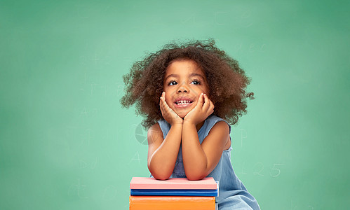 童年,学校教育快乐的微笑小非裔美国女孩与堆书绿色粉笔板背景带着书的非裔美国女学生图片