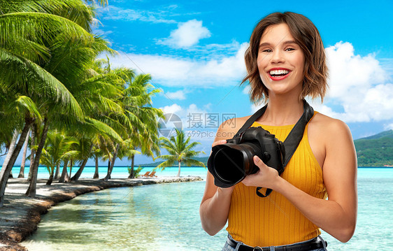 旅行,旅游摄影快乐的女摄影师芥末黄色顶部与数码相机热带海滩背景法属波利尼西亚快乐的女摄影师带着相机海滩上图片