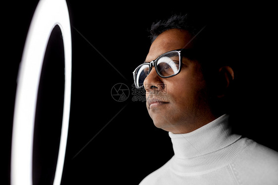 未来的技术,增强现实视觉印度男子戴着眼镜,白色照明,黑色背景戴眼镜的人白色的照明下超过黑色图片