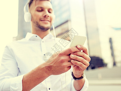 人,技术生活方式有智能手机耳机听音乐的人男人带着智能手机耳机听音乐图片