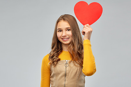 情人节,爱人的微笑的年轻女孩,红色的心灰色的背景带着红心微笑的十几岁女孩图片
