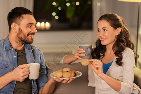 休闲人们的快乐的夫妇家里喝茶或咖啡加饼干幸福的夫妇家喝茶饼干图片