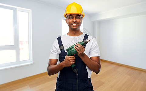 专业,建筑建筑快乐微笑的印度修理工或建筑工人戴着头盔,空房间背景上用电钻或穿孔器快乐的印度建筑工人戴着电钻的头盔图片