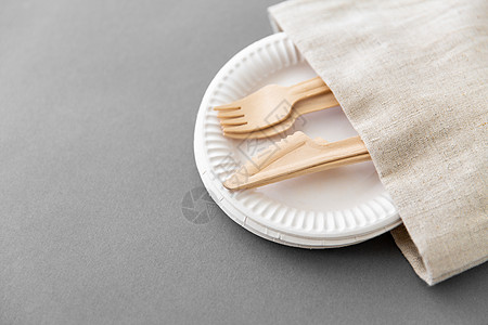 餐具,回收生态友好的木叉刀纸盘帆布餐巾灰色背景纸盘餐巾上的木叉刀图片