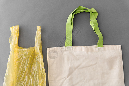 消费主义,回收生态友好的可重复用的帆布手提包,用于食品购物塑料袋的灰色背景塑料袋可重复用的手提包用于食品购物背景图片