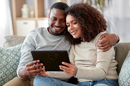 技术,互联网人的快乐的非裔美国人夫妇与平板电脑家里非裔美国人夫妇家里有平板电脑图片