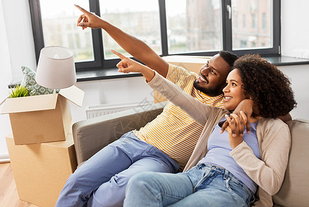 移动,人,维修房地产快乐的非裔美国人夫妇,纸板箱坐沙发上的新家幸福的夫妇带着箱子搬到新家图片