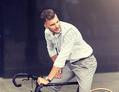 生活方式,交通人们的年轻人骑自行车耳机城市街道城市街道上有自行车耳机的男人图片