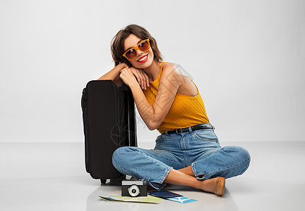 旅行,旅游度假的快乐的微笑年轻妇女芥末黄色顶部与机票,相机,随身袋灰色背景带旅行袋机票相机的女人图片
