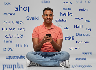 技术,沟通人的快乐的印度男子用智能手机问候语同的外语灰色背景快乐的印度男人用智能手机图片