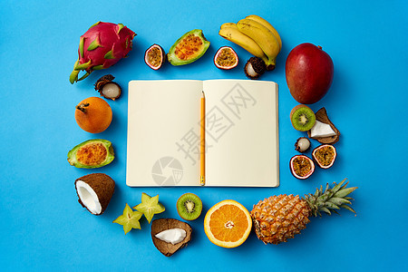 食物,饮食健康饮食同的异国水果围绕笔记本或日记与铅笔空页蓝色背景带空页的笔记本周围的异国水果图片