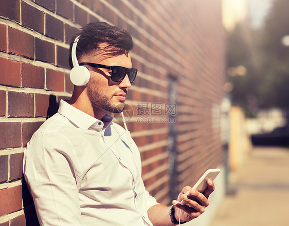 人,技术生活方式快乐的年轻人带着耳机智能手机城市听音乐带耳机智能手机听音乐的男人图片