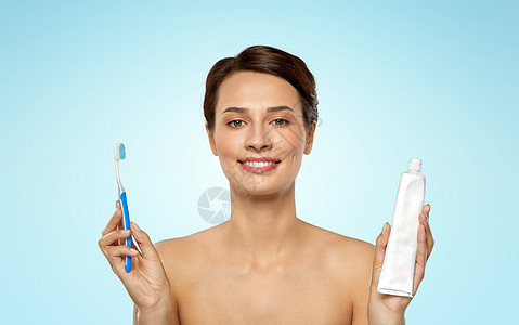 口腔卫生,牙科护理健康理念微笑的女人用牙刷牙膏清洁蓝色背景的牙齿微笑的女人用牙刷清洁牙齿图片