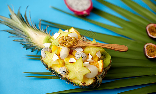 食物,夏季健康的饮食混合同的异国水果菠萝与木勺绿色扇棕榈叶蓝色背景菠萝中异国水果与勺子的混合图片