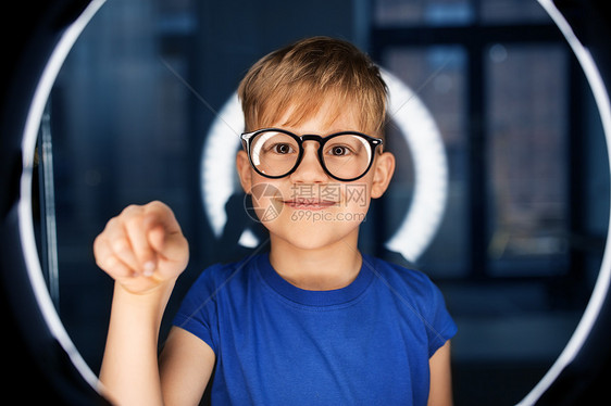 未来的技术,虚拟现实视觉快乐的微笑男孩戴着眼镜,黑暗的房间里触摸着白色照明上看见的东西黑暗的房间里戴眼镜的男孩图片