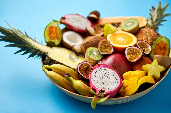 食物,夏天健康的饮食蓝色背景上同异国水果的盘子蓝色背景上的异国水果盘子图片