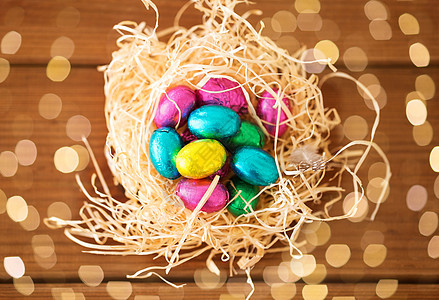 复活节,糖果假日巧克力鸡蛋稻草巢木桌子上桌子上稻草巢里的巧克力复活节彩蛋图片