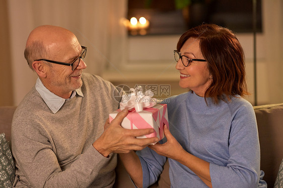 假日人们的快乐的老年夫妇家里有礼品盒幸福的老年夫妇家带礼品盒图片